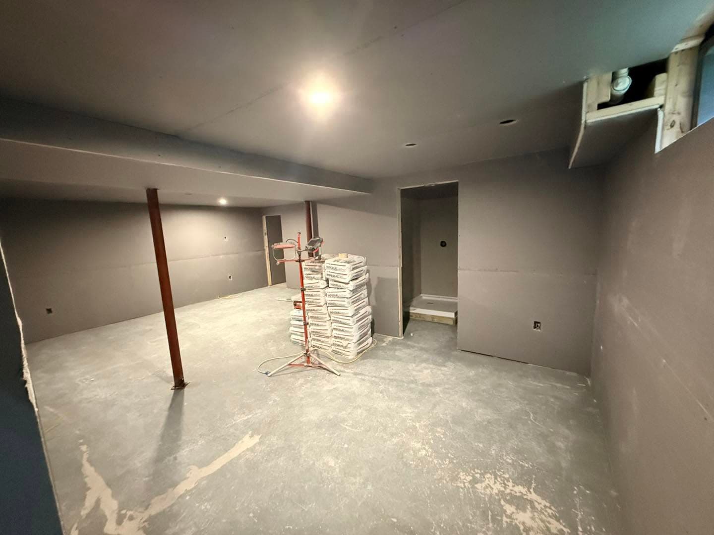 Unfinished basement with concrete floor and framing