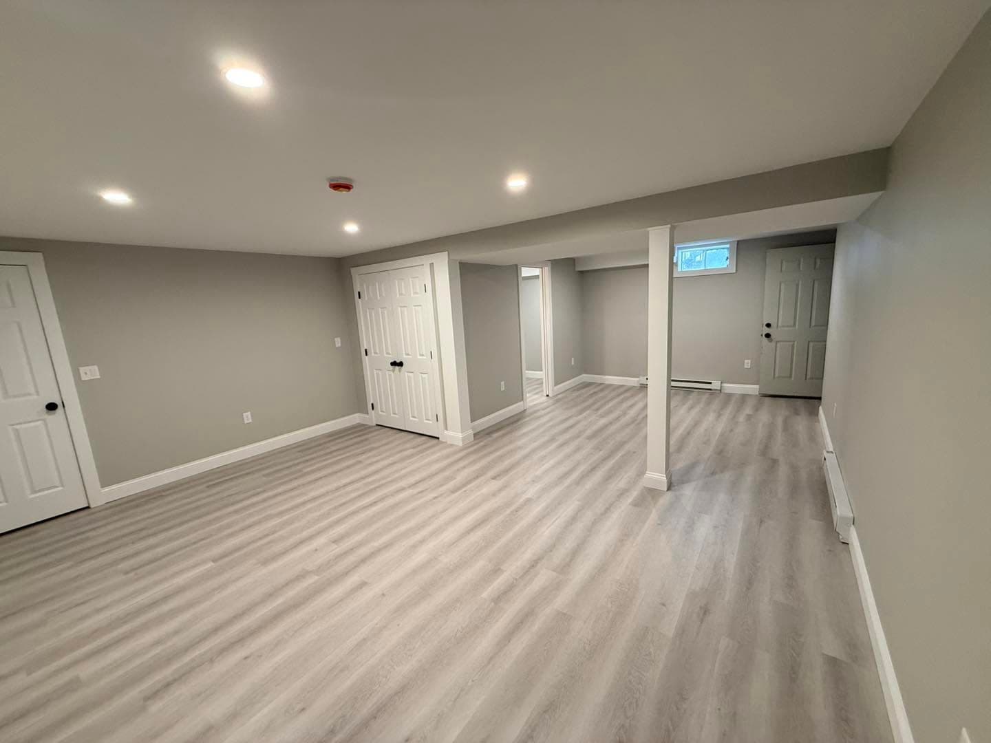 Finished basement living area with LVP flooring and recessed lights