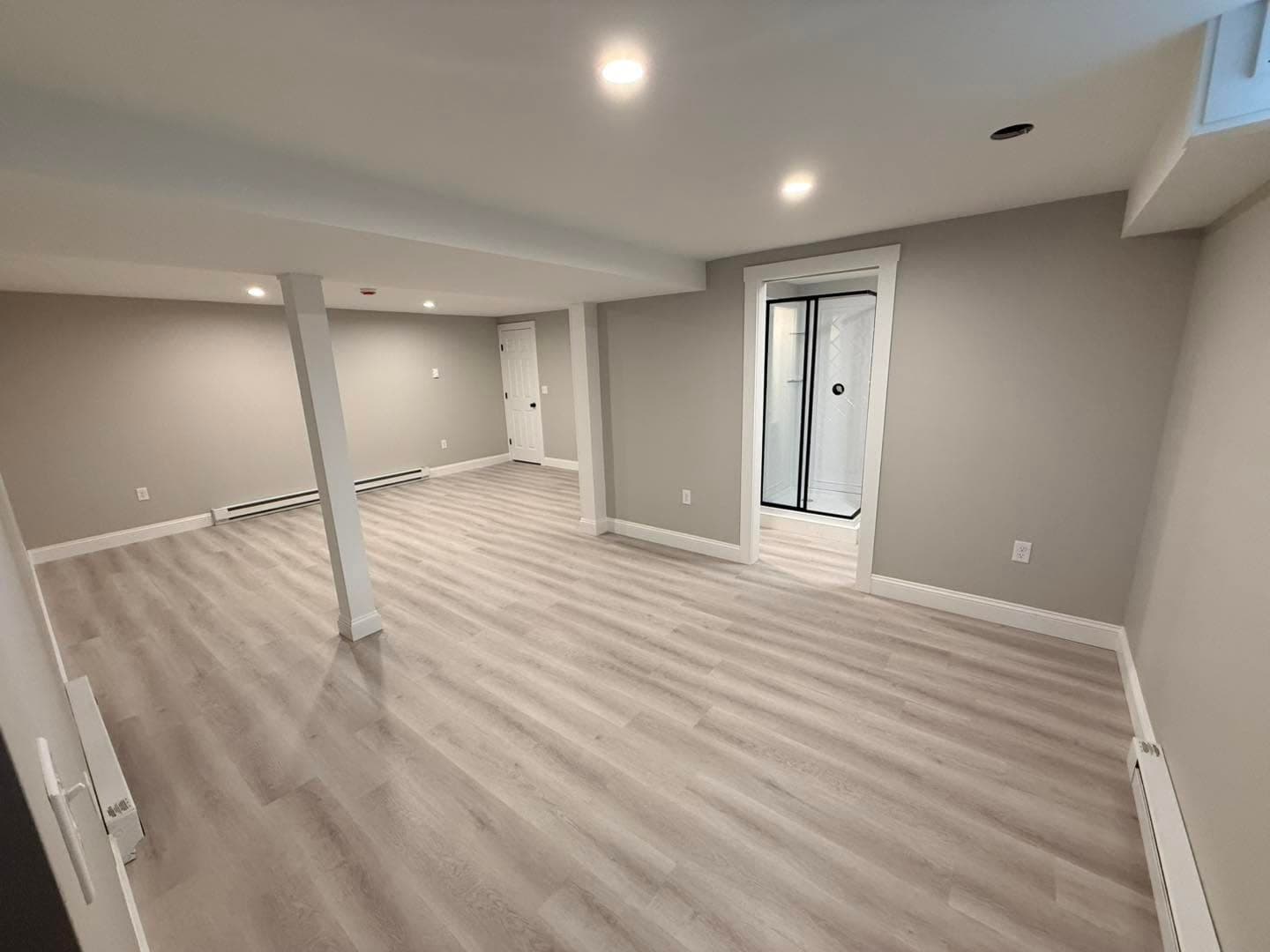 Finished basement with LVP flooring and glass exterior door