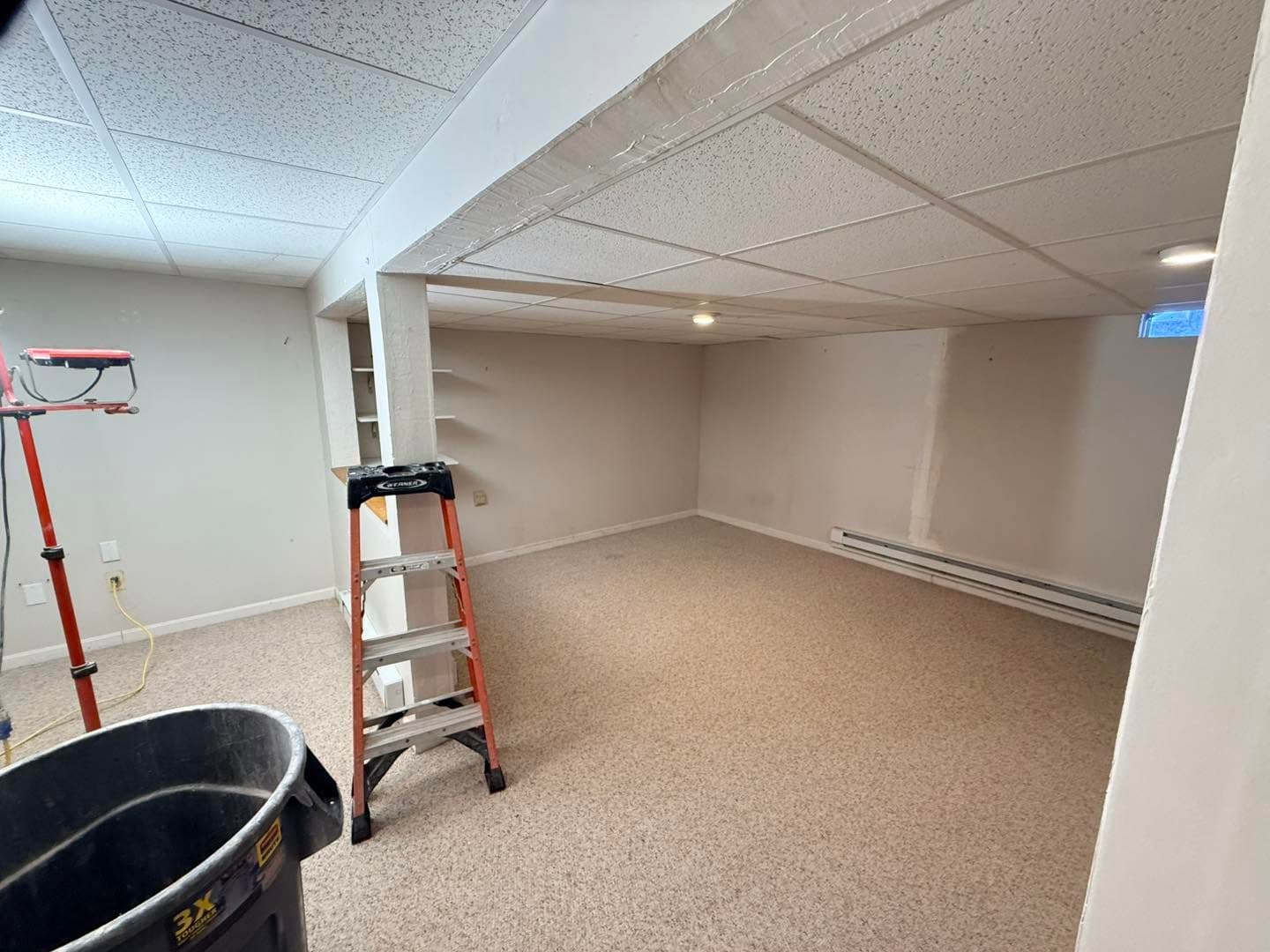 Wide view of finished basement with recessed lighting
