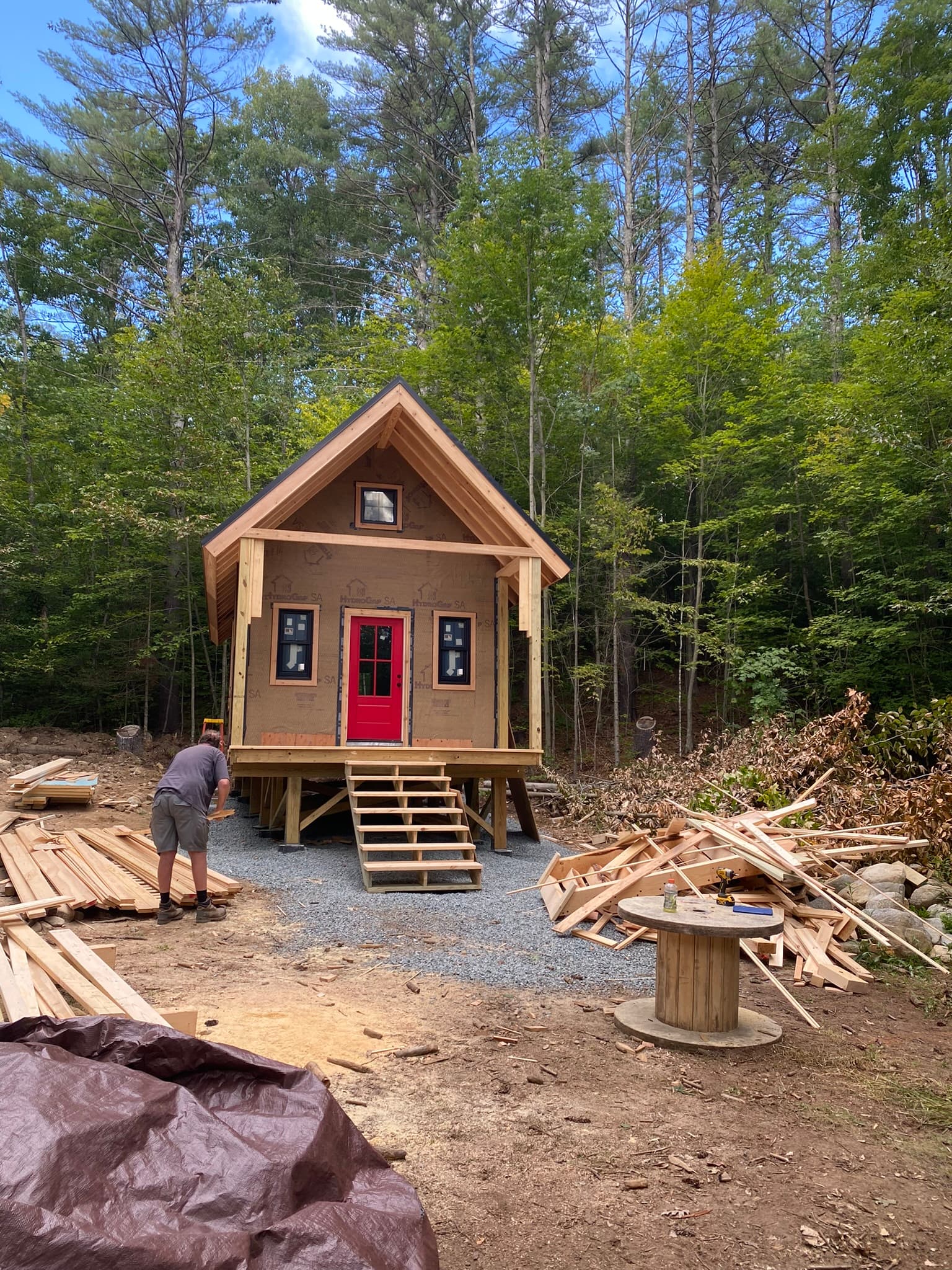 Cedar shake cabin with red door in wooded setting