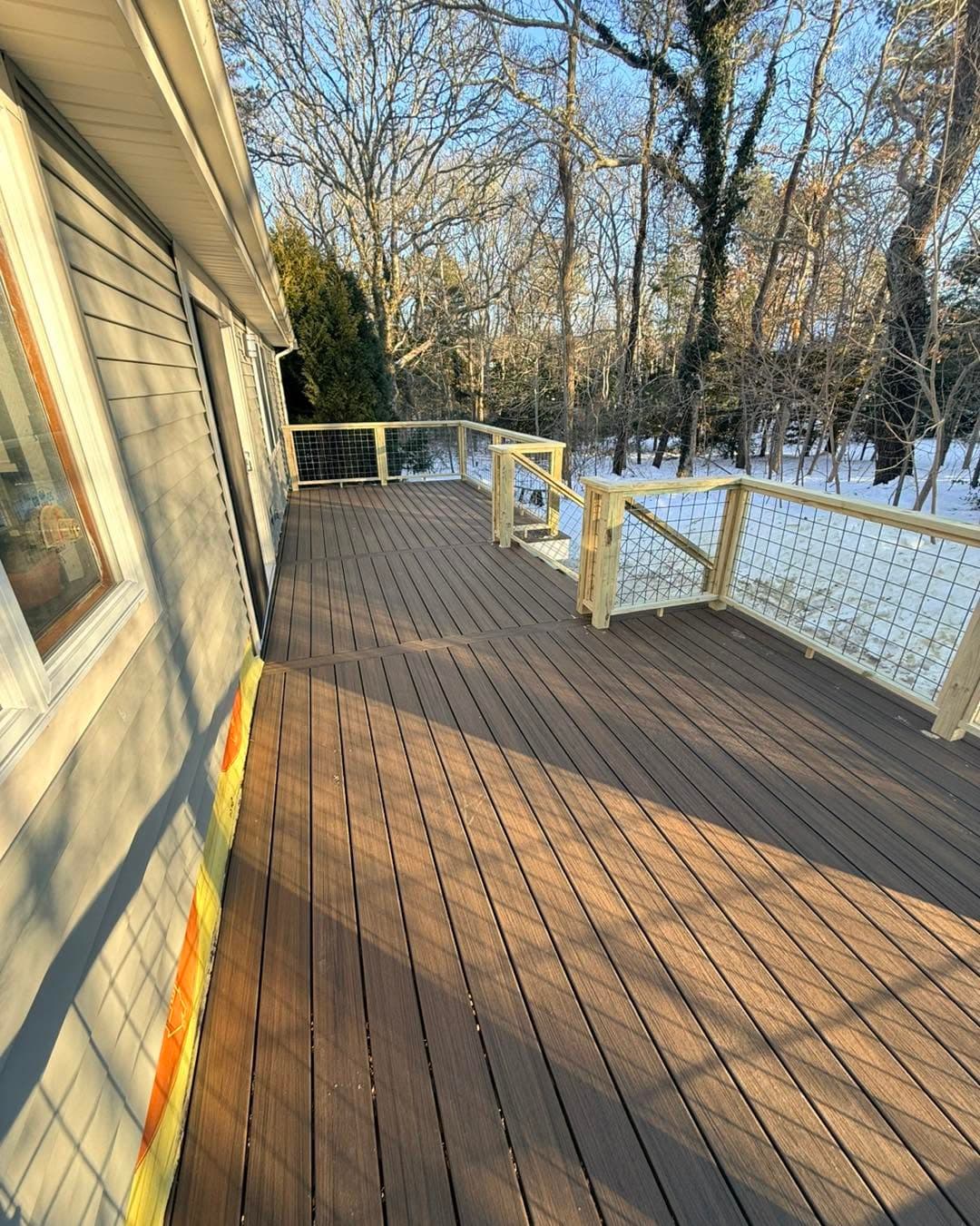 Composite deck running along the home toward the wooded yard