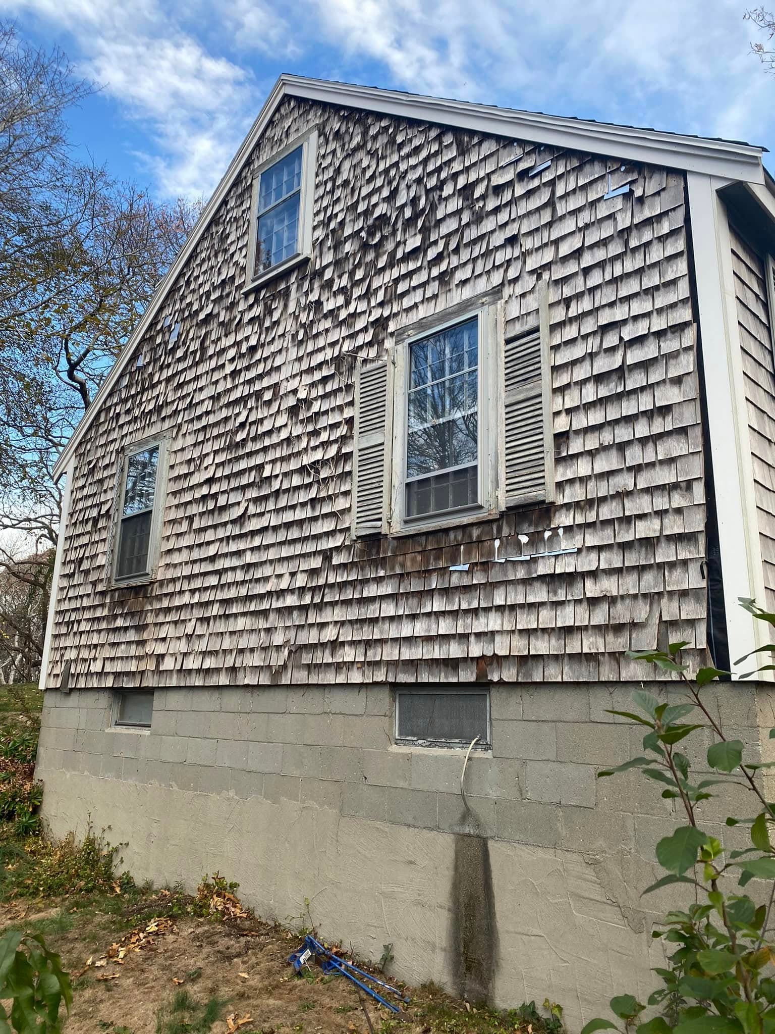 Cedar shingle siding on a home gable with windows
