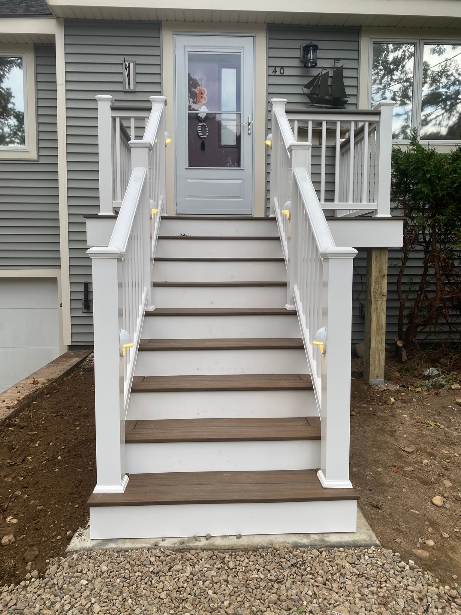 Front entry stairs with composite treads and white vinyl railings