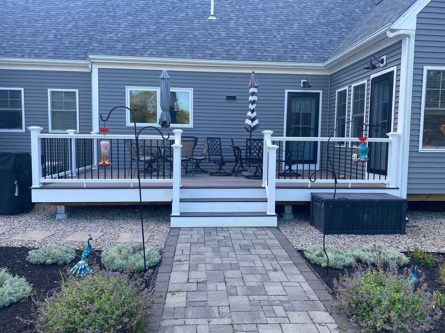 Farmer's porch with white railings over a paver patio