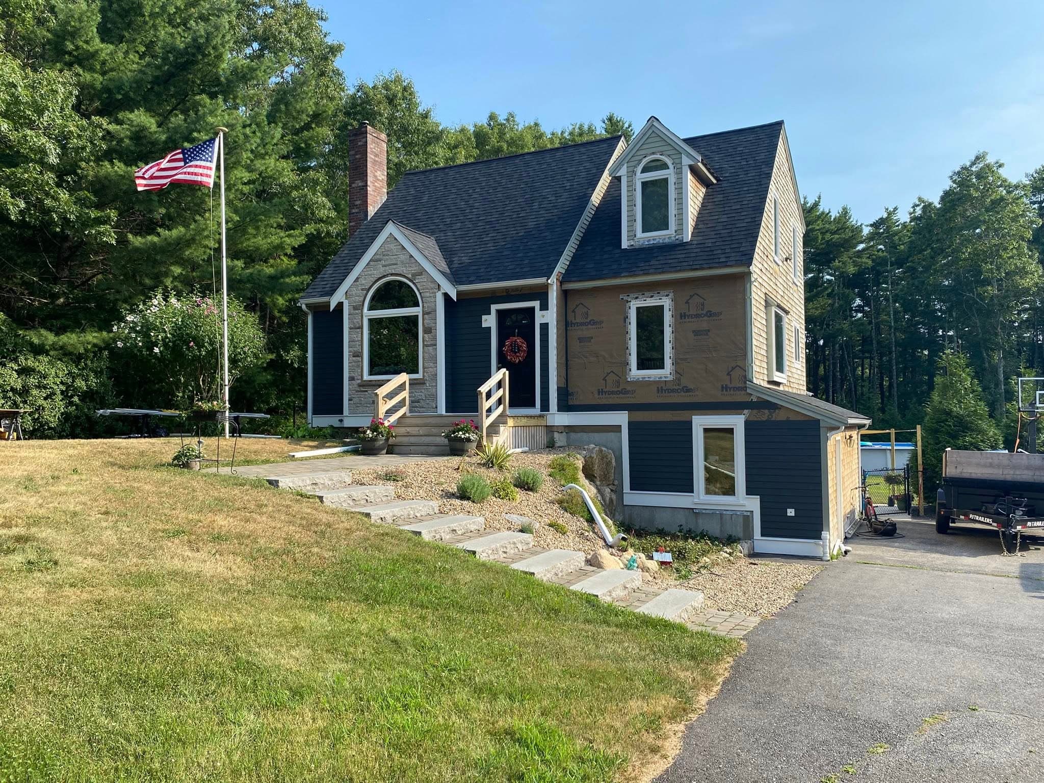 Front elevation of navy Cape home with American flag
