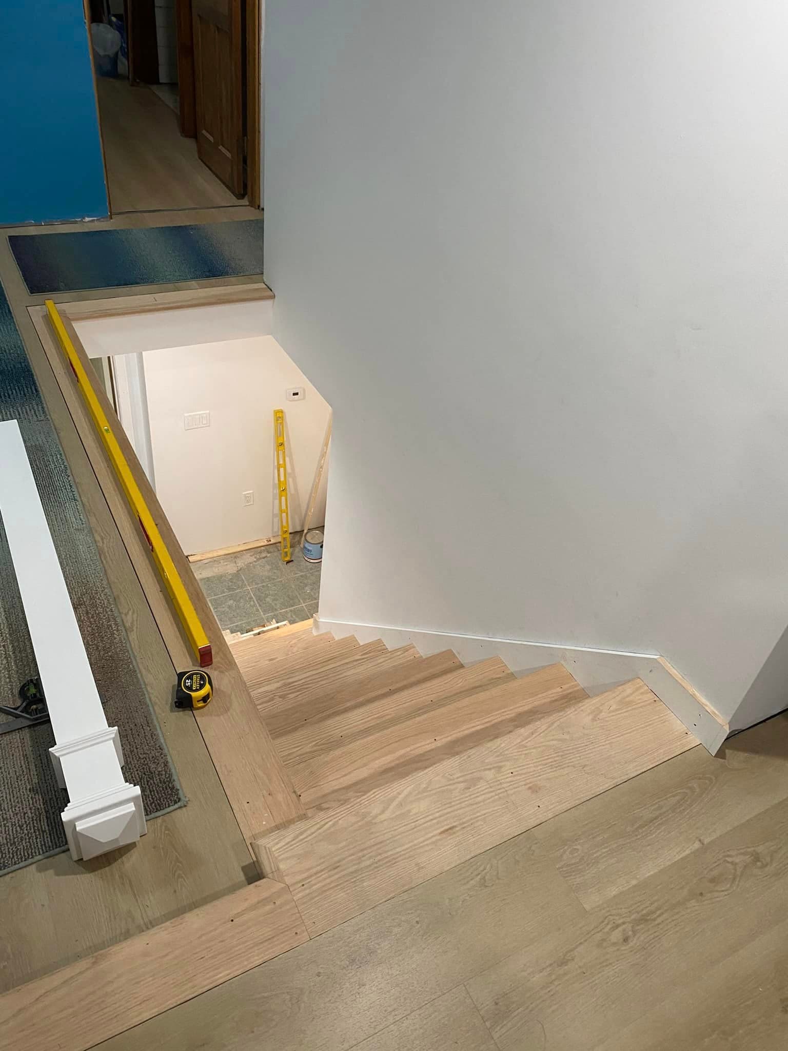 Finished staircase landing with white risers and wood flooring